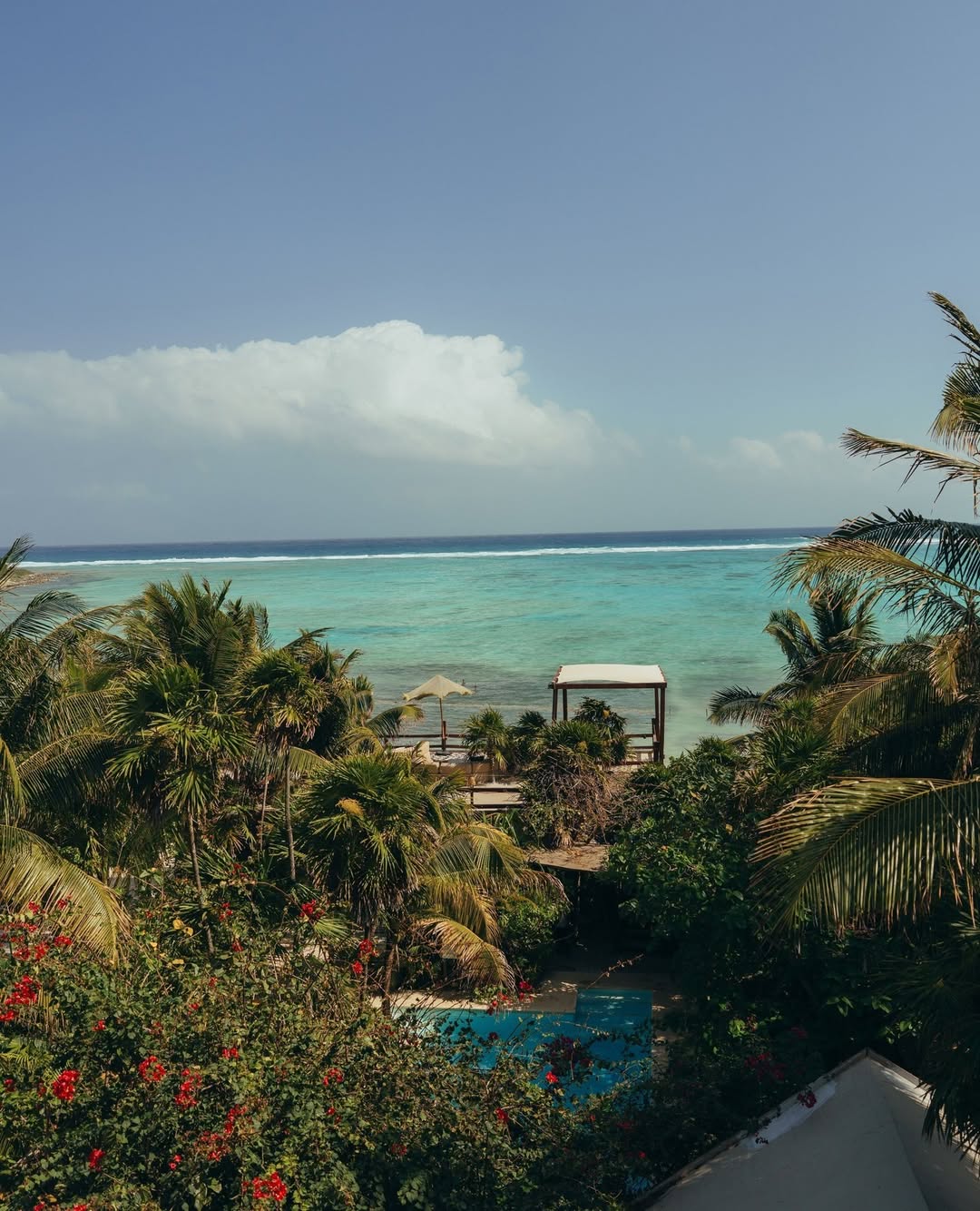 Aerial view of turquoise waters and thatched beachfront cabanas at Jashita Hotel, an exclusive oceanfront Tulum wedding venue.
