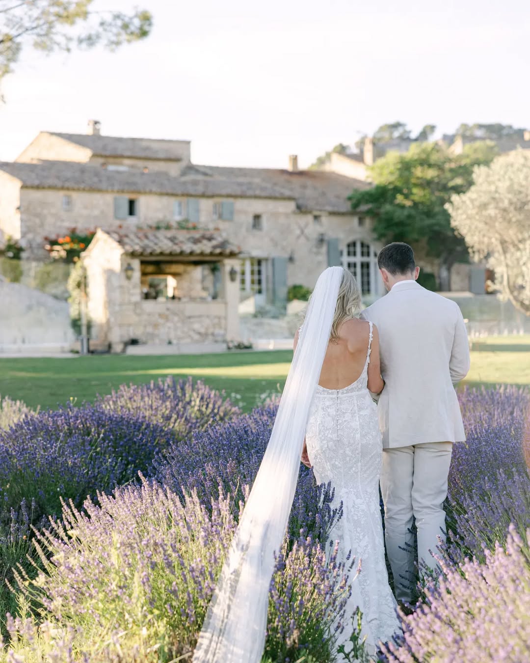 Bride and groom walk through blooming lavender fields at Le Mas de la Rose, epitomizing the romance and elegance of a Provence France wedding.