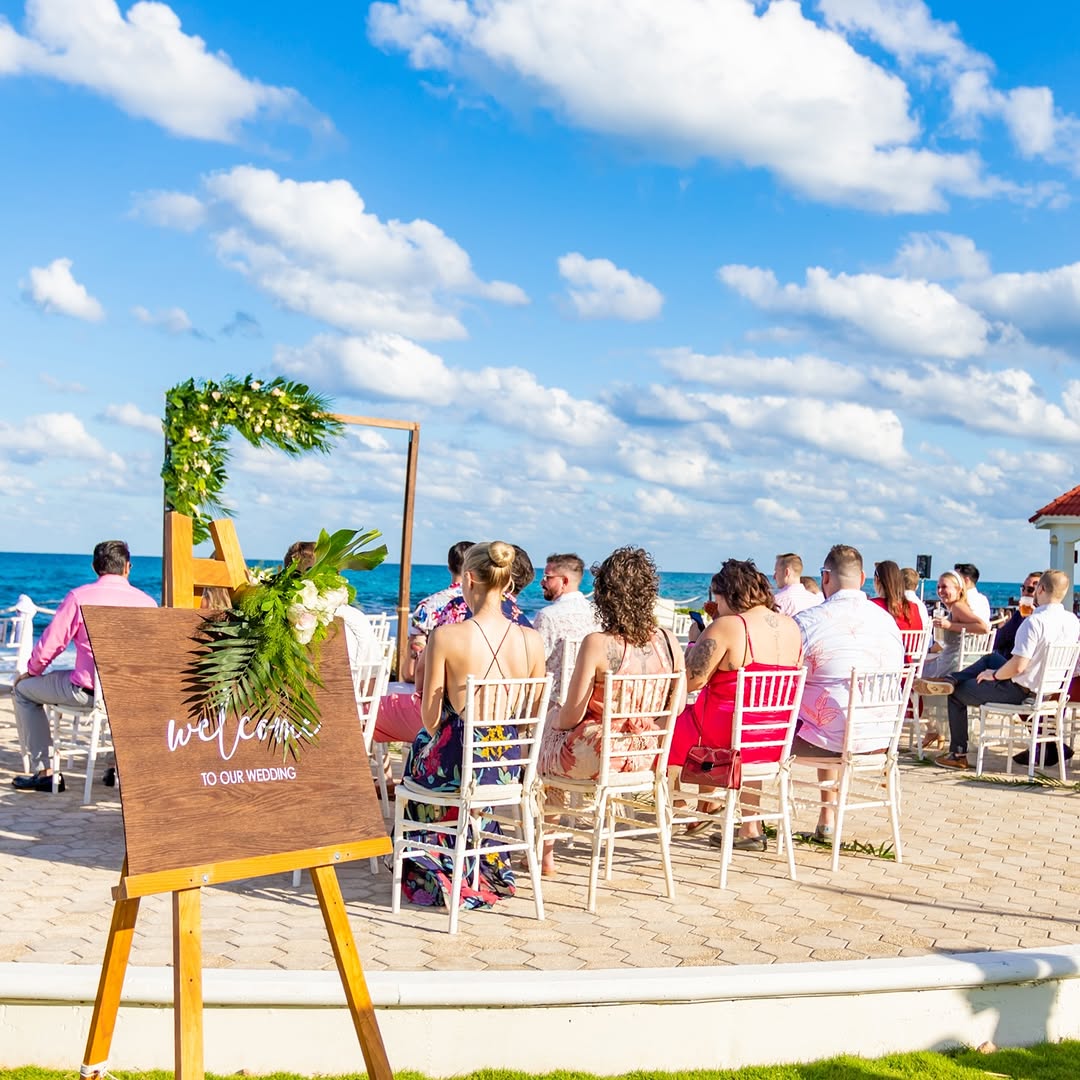 Outdoor wedding ceremony by the ocean at Mia Reef Isla Mujeres, featuring tropical decor and stunning sea views.