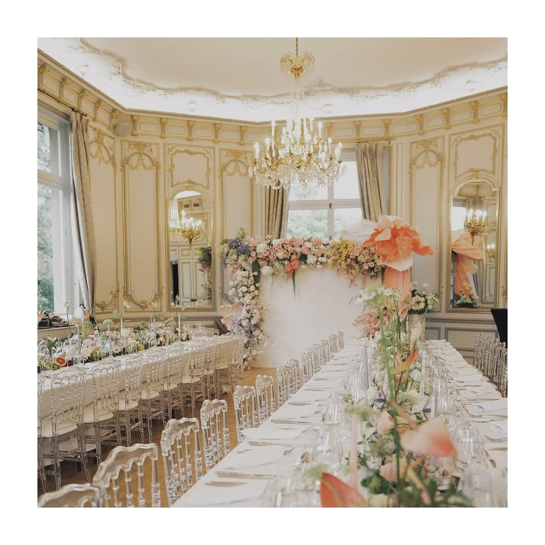 Light-filled reception room at Pavillon Royal with pastel florals and chandeliers, a charming Paris wedding venue near Bois de Boulogne.