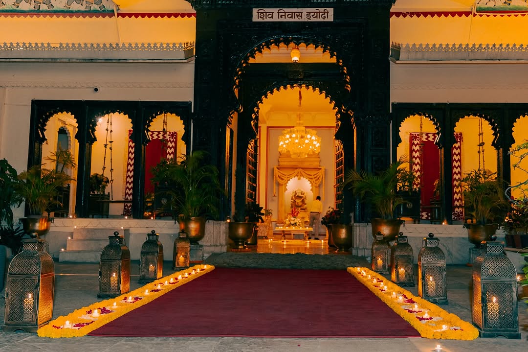 Nighttime entrance to Shiv Niwas Palace adorned with candles and floral decor, perfect for a grand Udaipur wedding celebration.