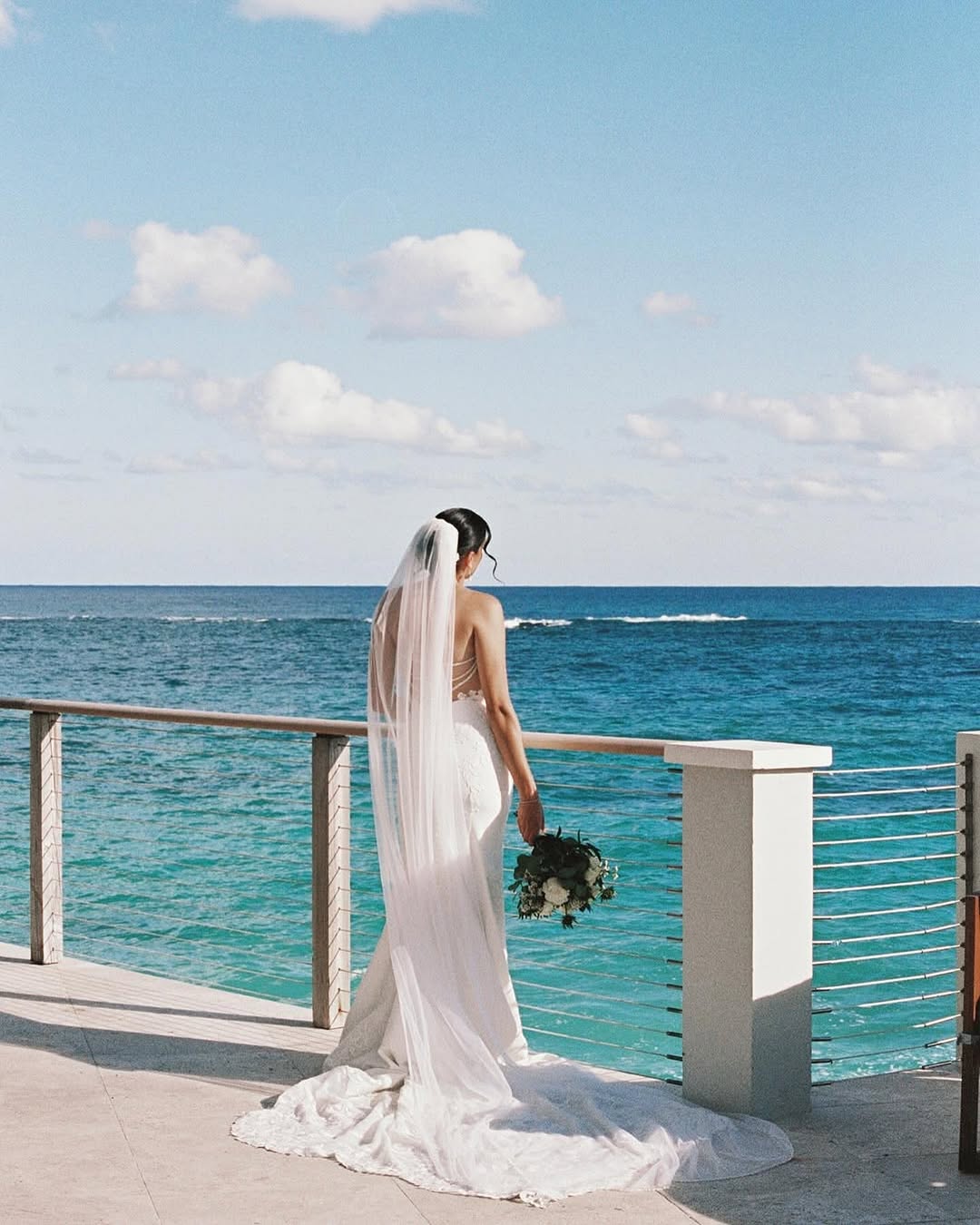 A couple walks along the blush-toned sands and dramatic limestone rock formations of Pink Beach near The Loren, a dreamy backdrop for Bermuda weddings.