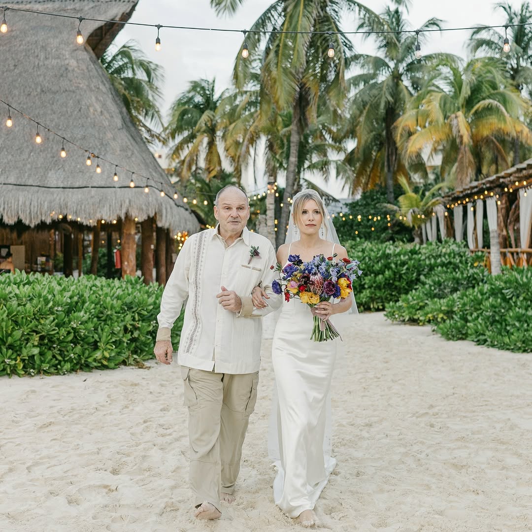 Bride walking down a sandy aisle at Zama Beach Club, a laid-back and stylish venue for an Isla Mujeres wedding celebration.