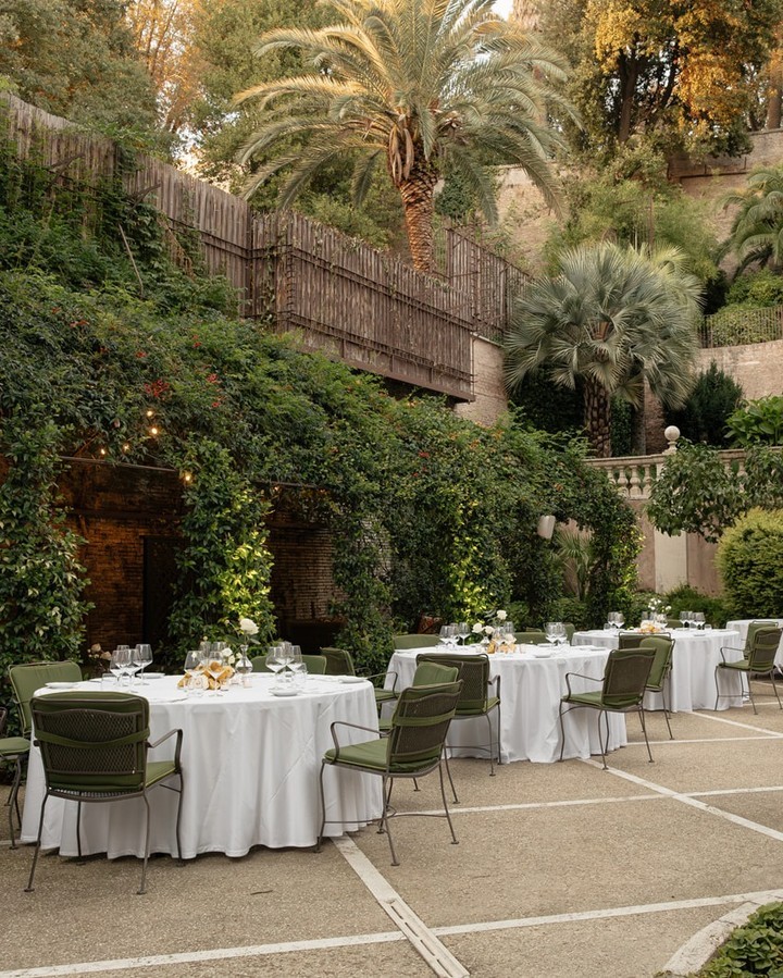 Charming garden terrace at Hotel de Russie in Rome, surrounded by lush greenery and palm trees, offering an intimate wedding venue atmosphere.