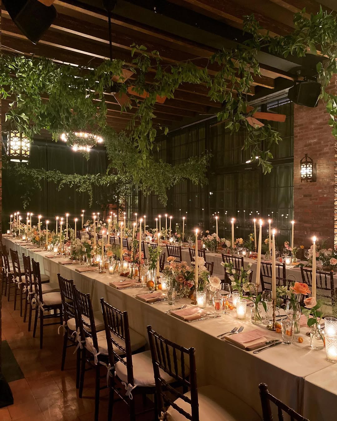 The Bowery Hotel in New York City offers a romantic candlelit atmosphere with exposed brick and lush greenery for stylish indoor weddings.