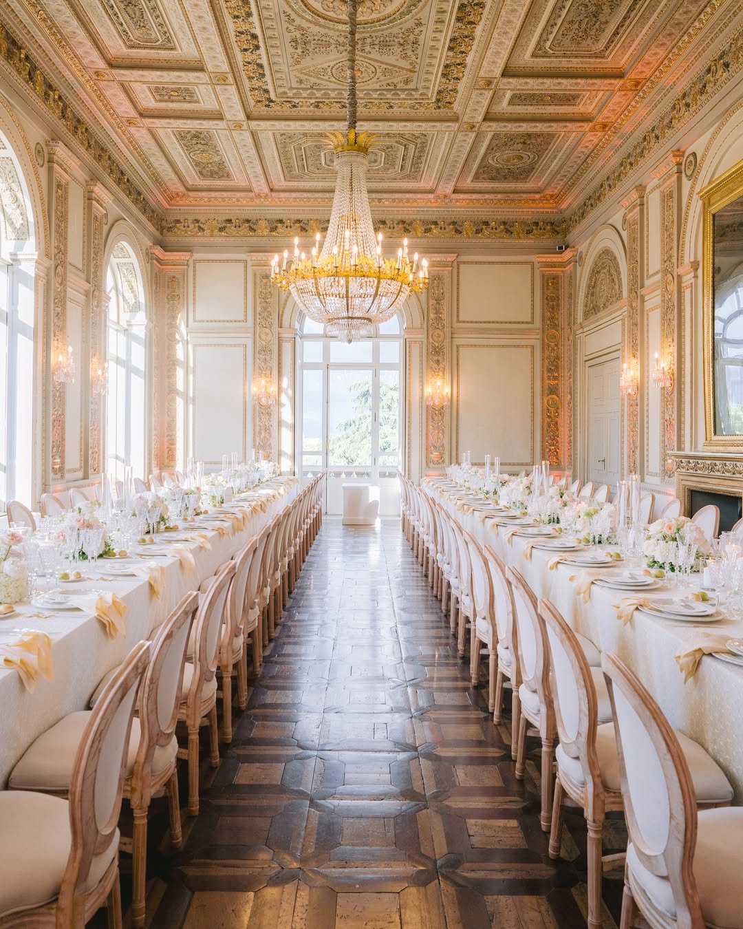 Ornate dining hall at Villa Aurelia in Rome, featuring gilded ceilings, crystal chandeliers, and long banquet tables for a grand wedding celebration.