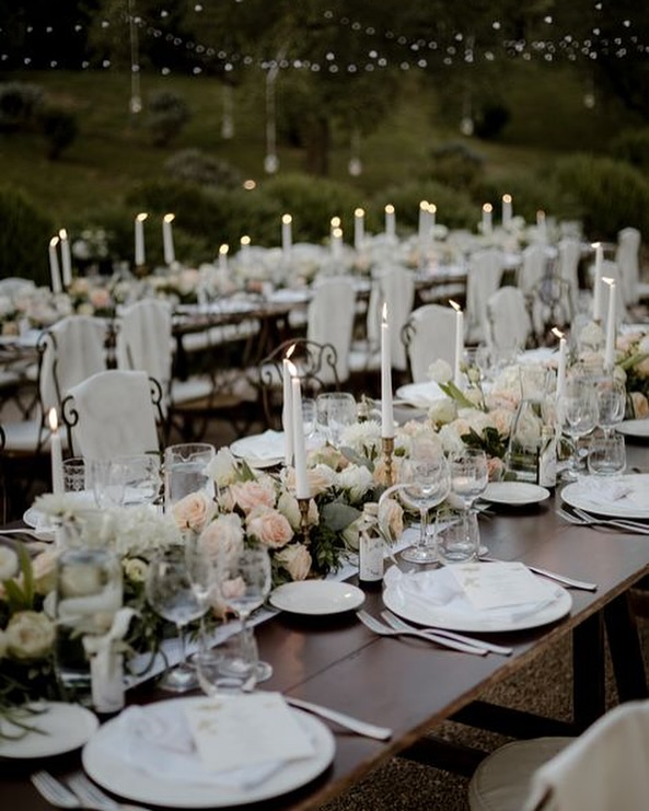 Romantic candlelit garden dinner setup at Villa Dino in Rome, with white flowers and soft lighting, perfect for elegant outdoor Rome weddings.